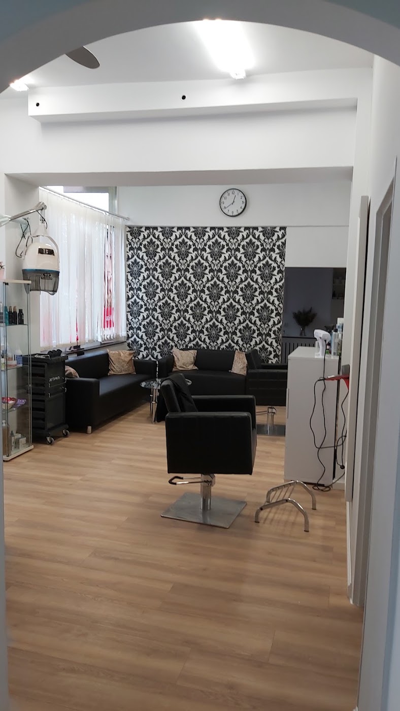 Wnętrze salonu fryzjerskiego z fotelami, lustrami i wzorzystą ścianą